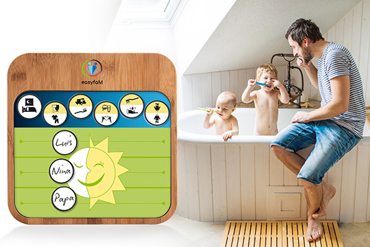 Vater mit zwei Kindern in der Badewanne, während ein interaktives Gerät im Vordergrund zu sehen ist.