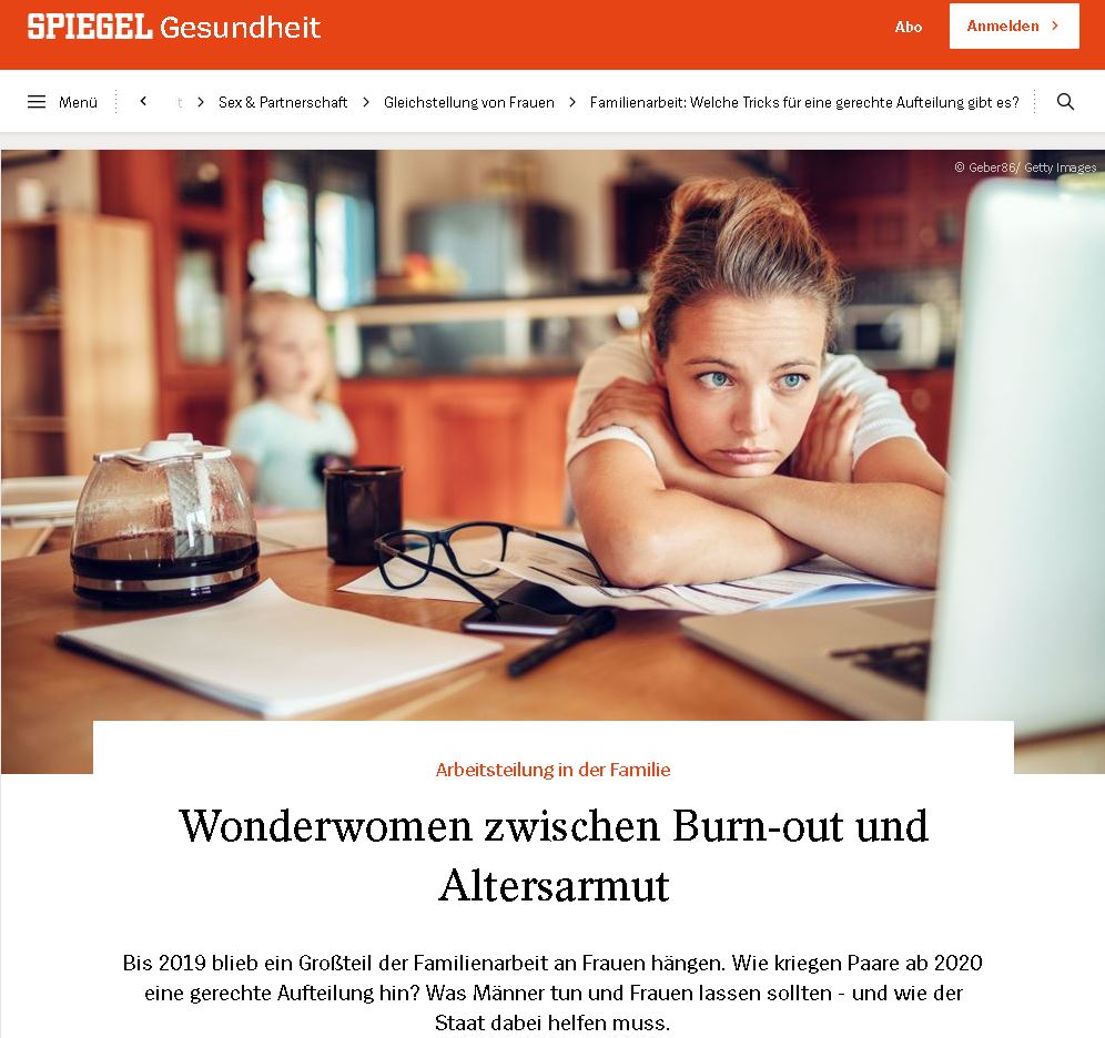 Eine nachdenkliche Frau sitzt an einem Tisch mit Unterlagen und Getränken, während ein Kind im Hintergrund spielt.