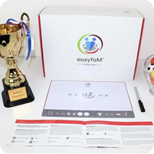 A trophy, instructions, and a box with the "easyfaM Challenge" logo are on a table.
